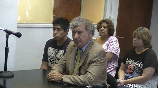 El acusado junto a su defensor y detrás familiares