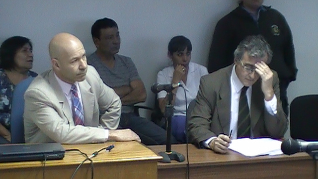 El fiscal general Omar Rodríguez y detrás los padres de las víctimas